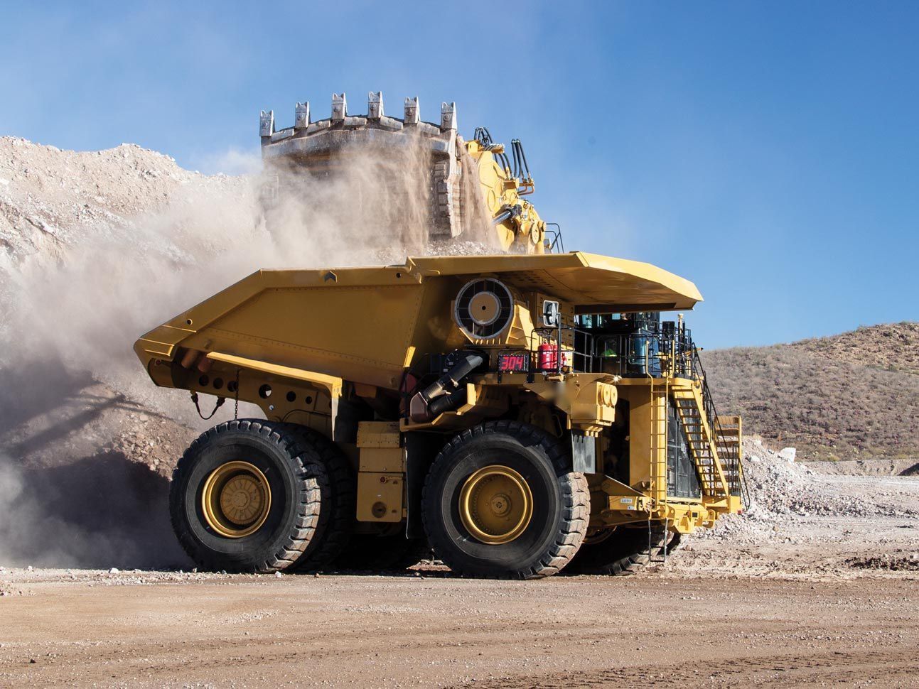 Camión de extracción minera cargado por una pala en faena